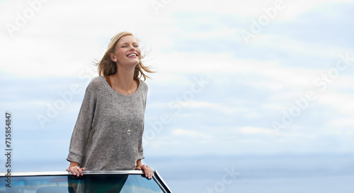 Smile, blue sky and convertible car with woman on road trip for travel, vacation or holiday in summer. Mockup, driving and journey with happy young person in vehicle for transport in fresh air photo
