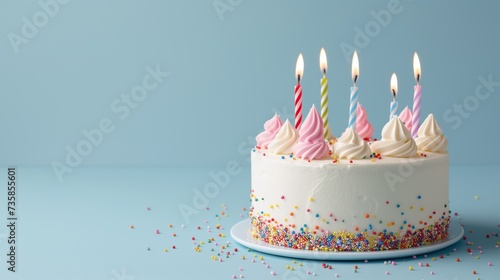 Festive happy birthday banner with a cake with candles on a blue background. Horizontal photo with a cute cake, studio photo, copy space.