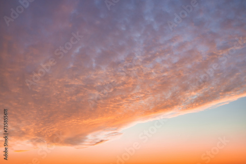 A beautiful sky tinted by the sun leaving vibrant shades of gold, pink, blue and multicolored. Clouds in the twilight evening and morning sky. Cloudy sky background in the evening and during the day.