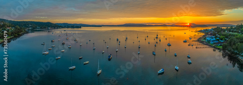 Aerial sunrise over the water with boats and clouds