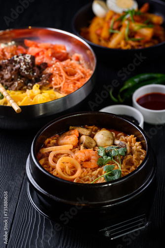 Korean food. seafood soup, salmon, eel, shrimp. on a black wooden background.