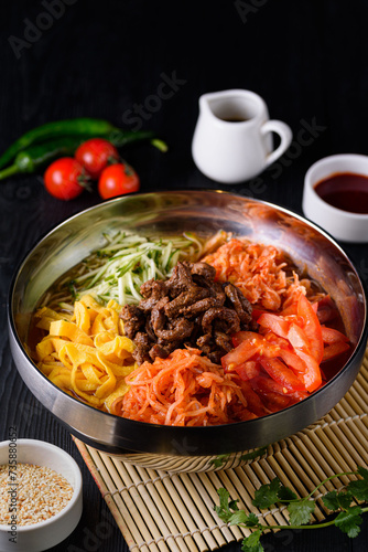 Korean food. Cooksey in a metal plate on a black wooden background.