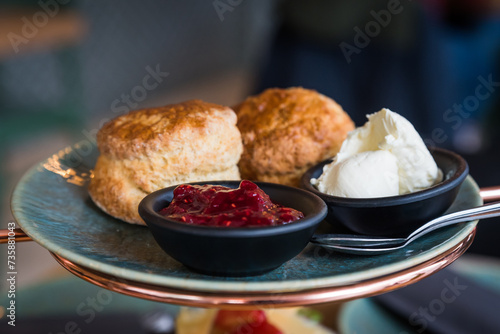 English scones on a plate in bakery with jam and clotted cream photo