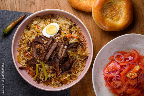 pilaf with meat, tomato salad and bread