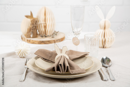 Gedeckter Tisch mit Serviette und Ostern Dekoration in Naturfarben photo