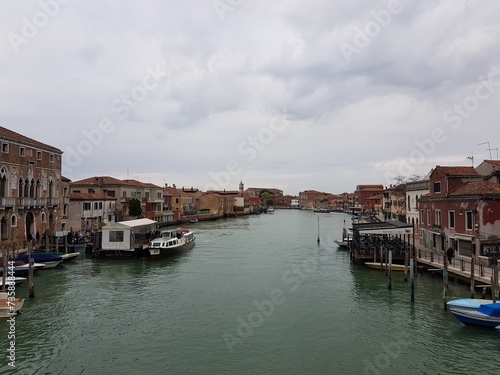 Canal view from Murano, Venice with boats and brown houses