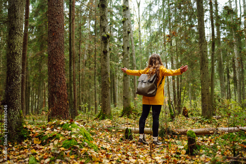 Pretty woman carrying a backpack in the forest in the autumn season. Traveler enjoying nature. Concept of trekking, active lifestyle. Adventures. Pretty woman carrying a backpack in the forest in the autumn season. Traveler enjoying nature. Concept of trekking, active lifestyle. Adventures.