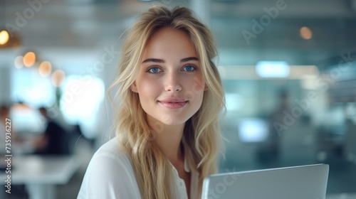 A cute blonde young woman working at desk in office with glass partitions. Generative AI.