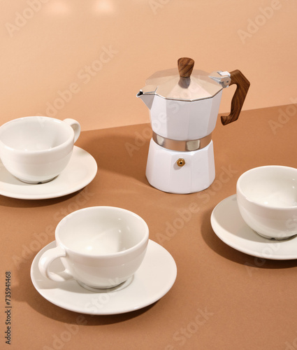 Moka coffee pot for making deliciously aromatic coffee and beautiful table setting with ceramic tableware.