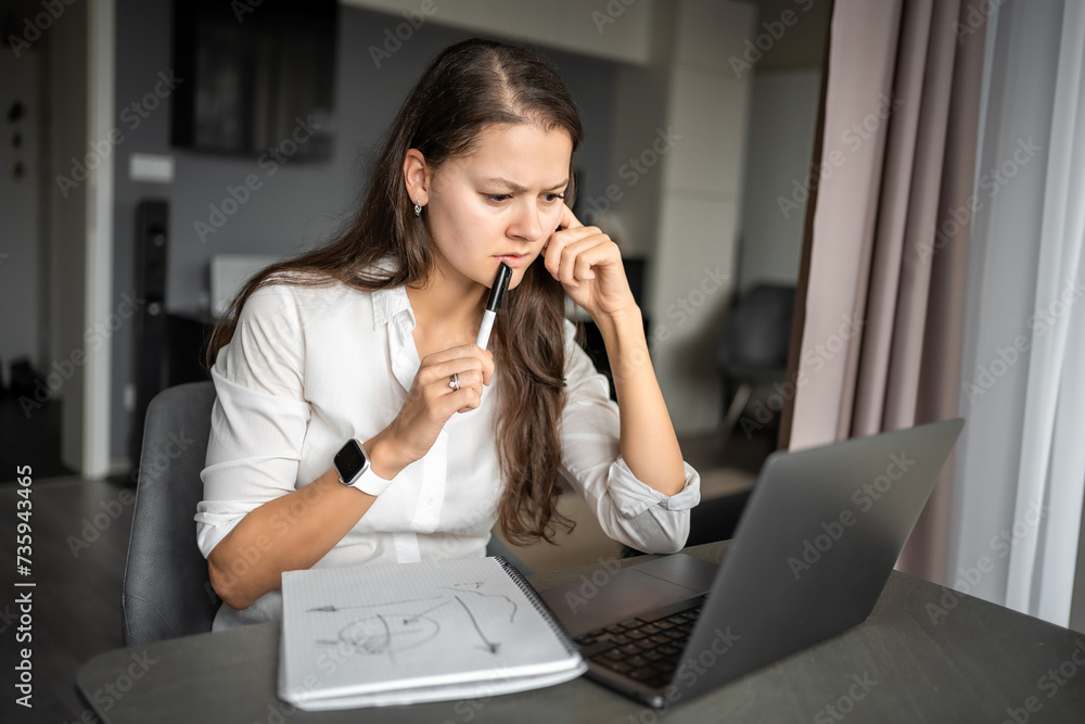 Young tired woman using laptop in home workplace, writing notes, female student learning and watching online webinar or listening audio course, e-learning education concept. Young tired woman using laptop in home workplace, writing notes, female student learning and watching online webinar or listening audio course, e-learning education concept.