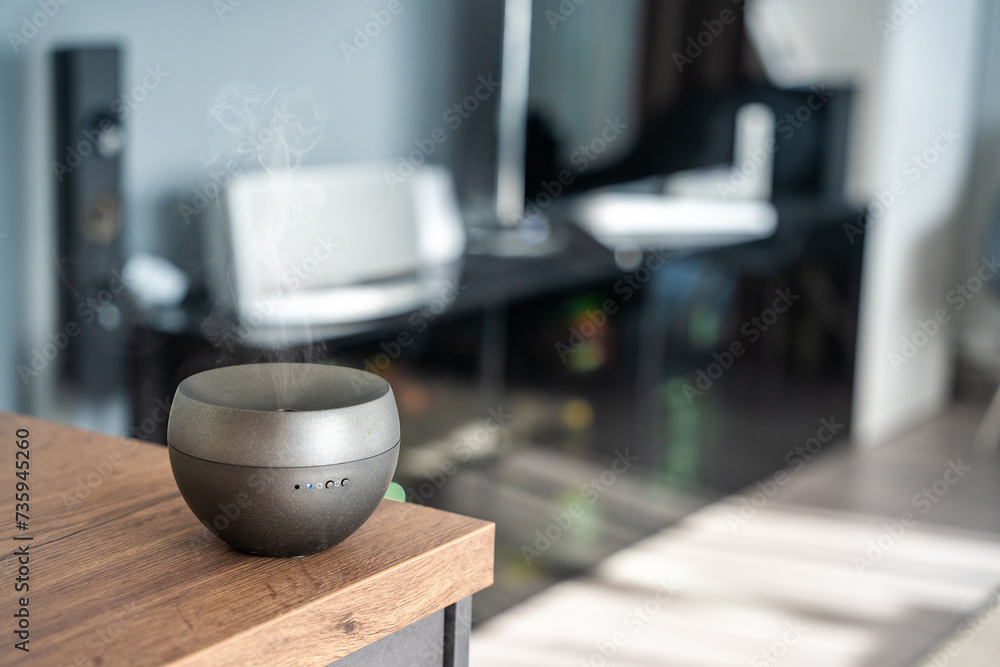 Grey aroma oil diffuser on light table at home, space for text. Air freshener Grey aroma oil diffuser on light table at home, space for text. Air freshener