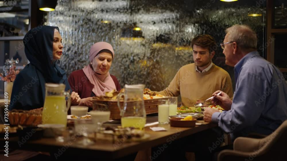 Young Muslim Married Couple Having Dinner and Talking with Man's Parents Young Muslim Married Couple Having Dinner and Talking with Man's Parents