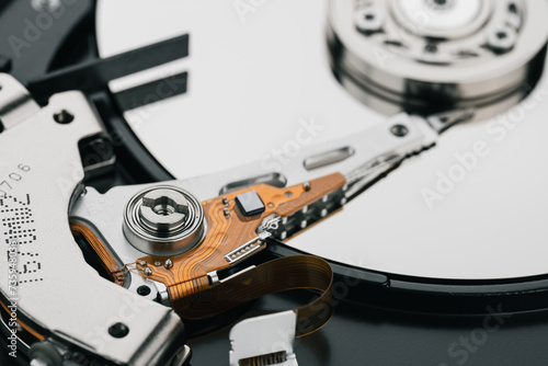 Hard drive isolated on white background. HDD. Major components of a 3.5-inch SATA hard disk drive: platter, spindle, actuator, actuator arm. Disk head above the plates	 photo