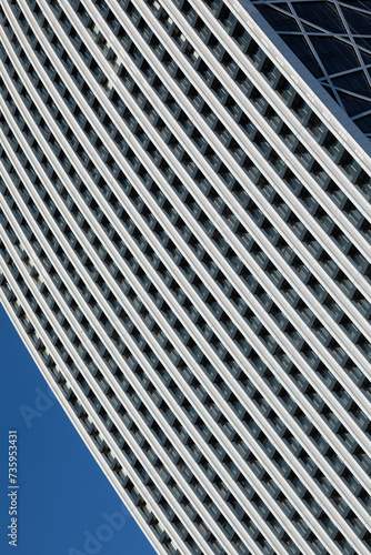 Obraz na płótnie A minimalistic photo of a part of a modern building with repetitive pattern on its exterior stands out against the clear blue sky w salonie