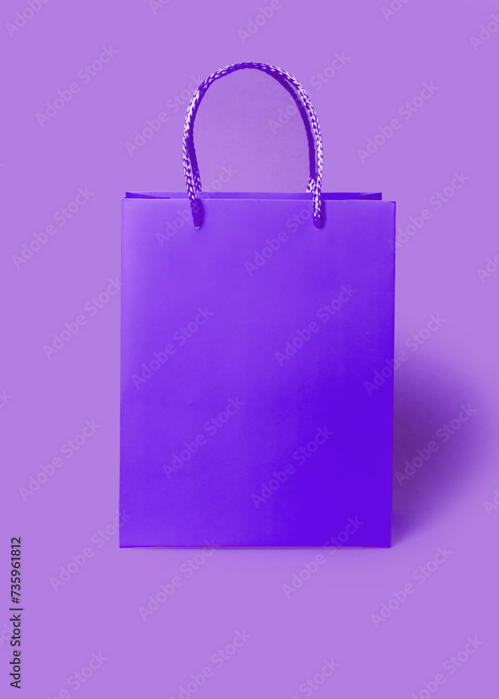 Purple shopping paper bag on purple background. Shopping sale. Delivery concept. Packaging gift. Purple shopping paper bag on purple background. Shopping sale. Delivery concept. Packaging gift.