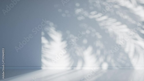 3D animation - Shadow of palm leaves moving in the wind in a loop on an empty light blue room wall at sunset