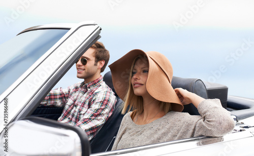 Couple, convertible and driving on road or adventure in California or outdoor journey, sun hat or vacation. Man, woman and environment on mountain or relaxing trip with transport, weekend or happy