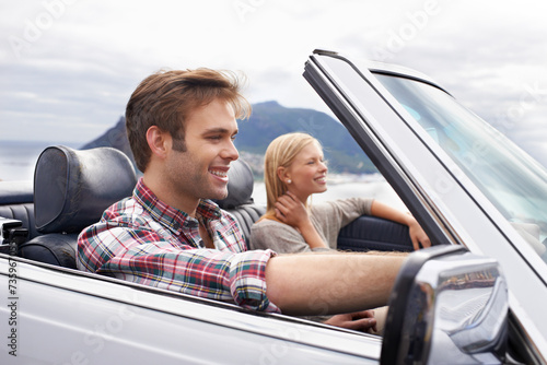 Couple, convertible and driving on mountain road in nature for bonding adventure for holiday, journey or travel. Man, woman and car in California for vacation destination or connection, trip or view