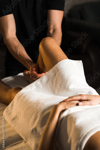 A professional masseur gives a massage to a young woman.Beautiful young woman enjoying massage in spa salon. Beauty treatment, skin care, wellbeing.Concept of massage and spa treatments © Darius
