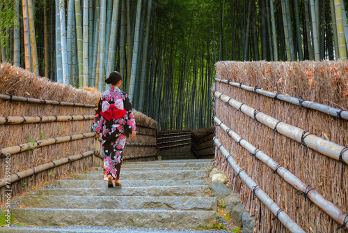 Young Japanese woman in a traditional Kimono dress strolls by the Bamboo Grove at Adashino Nenbutsuji Temple in Kyoto, Japan photo