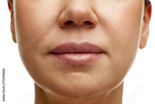 Cropped portrait of middle-aged woman with full moisturized pink lips with natural gloss and well-kept skin. Prevention of nasolabial folds. Concept of facial treatment, spa, cosmetology, anti-aging. photo