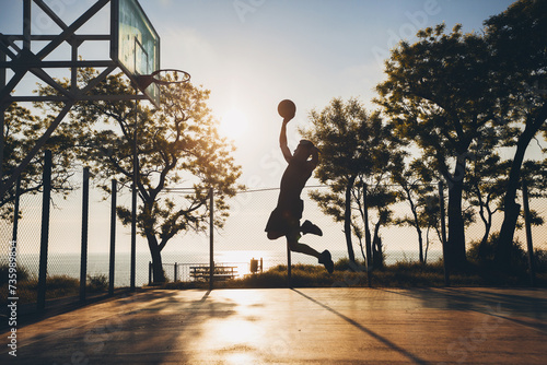 black man doing sports  playing basketball on sunrise  jumping silhouette