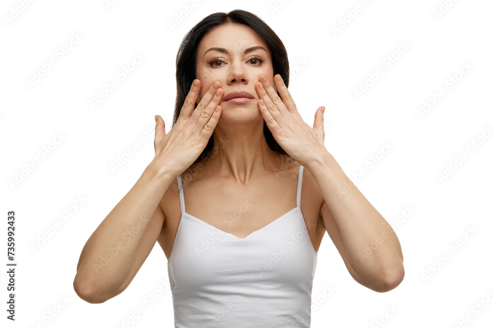 Middle aged woman doing facial massage improving skin tone and elasticity, stimulating its renewal against white studio background. Concept of beauty, anti-aging, self care, lifting and moisturizing. Middle aged woman doing facial massage improving skin tone and elasticity, stimulating its renewal against white studio background. Concept of beauty, anti-aging, self care, lifting and moisturizing.