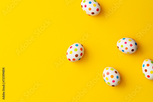 Spotty painted colorful easter eggs on yellow background. photo