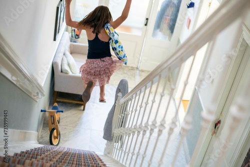 Young girl jumping down the stairs having fun photo