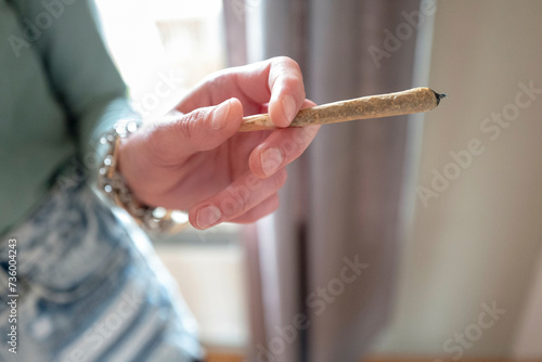 Hands of a woman holding a marijuana joint photo