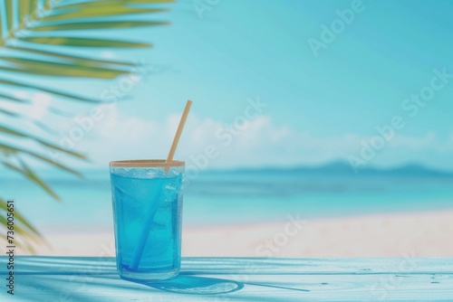 Tropical fresh Blue Curacao Cocktail near swimming pool on seacoast and ocean background. Copy space. Close up.