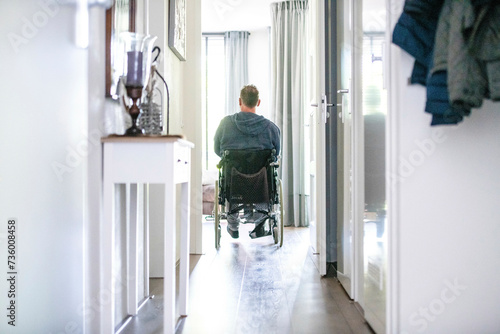 Man in wheelchair leaving the house to go to the shops photo