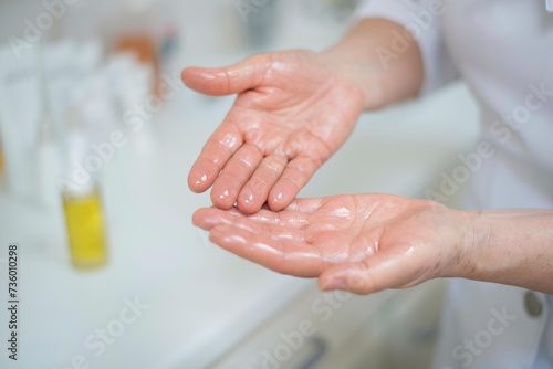Female Beauticians hands applying oil photo