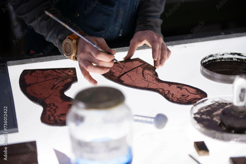 Apprentice female stained glass worker being taught lessons from
