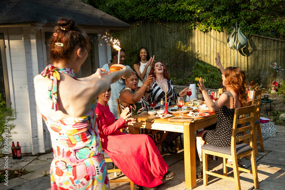 A mixed gathering of women laughing and having fun at a summer garden birthday party celebration lunch A mixed gathering of women laughing and having fun at a summer garden birthday party celebration lunch