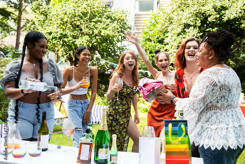 Mixed group of female friends / family at a summer garden BBQ party, laughing and having fun