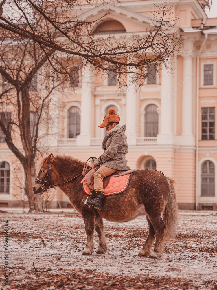 Naklejka premium boy is sad while sitting astride a pony