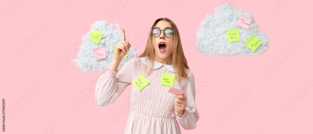 Young woman with raised index finger and many sticky notes on pink background. Reminder concept