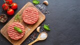 fresh raw hamburger patties or cutlet on brown board ready to cook on black textured background minced beef steak burgers with spices top view place for text