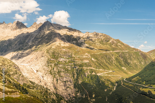 Mountainous landscape with pass road in the Swiss Alps. A winding mountain road with hairpin bends leads to Furka Pass, Obergoms, Canton of Valais, Switzerland