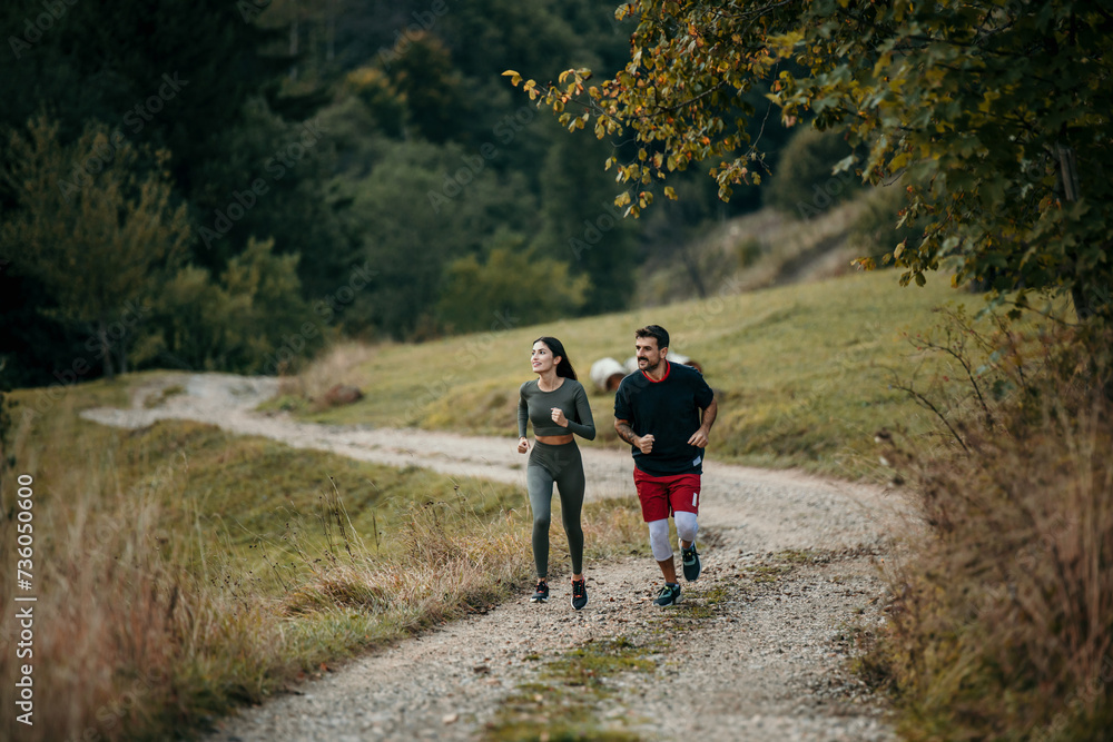 Active couple enjoying a morning run amidst breathtaking mountain scenery