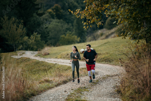 Active couple enjoying a morning run amidst breathtaking mountain scenery