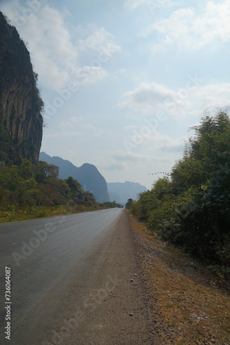 The route of the damaged road is mixed with a dirt road with views of forests and mountains on both sides.