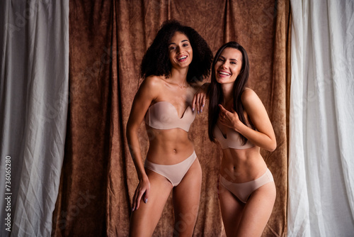 Photo of sweet happy women wear beige lingerie no retouch skin hugging laughing isolated natural daylight fabric linen background