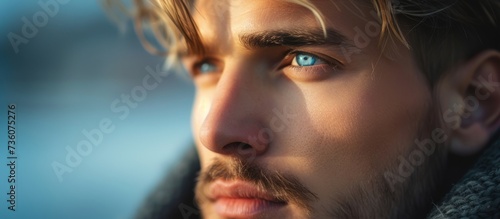 Portrait of a thoughtful man with a beard and striking blue eye looking into the distance
