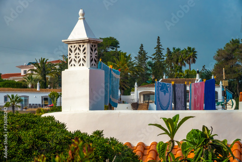 Quintessential Algarve: Algarvian chimneys (Chaminé Algarvia), drying clothes and subtropical vegetation, Portugal photo