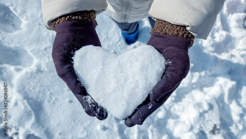 Female hands in knitted mittens with snowy heart against snow background stock photo © Sondem