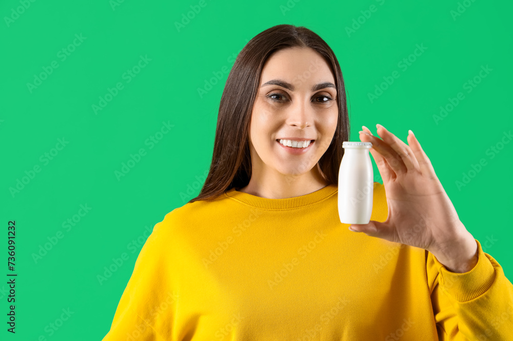 Young woman with bottle of tasty yoghurt on green background, closeup Young woman with bottle of tasty yoghurt on green background, closeup