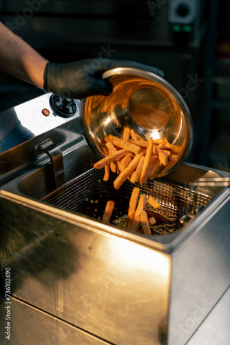 close-up of sweet potato fries poured into container with oil for frying