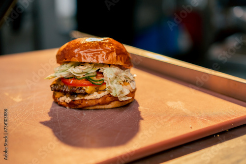 close-up of a ready-made large burger with beef in the kitchen of establishment lying on the table photo